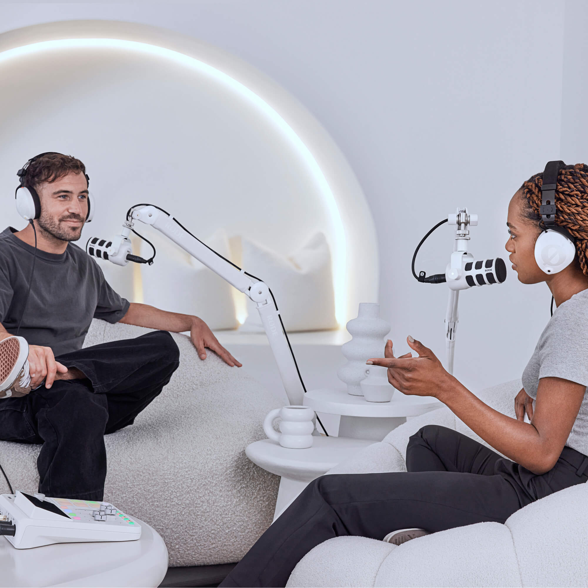 Bijeli krak RØDE PSA1+ i bijeli PodMic u svijetlom podcast studiju